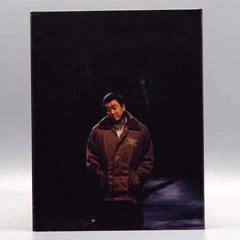 KimStim Only the River Flows Blu-Ray slipcover featuring a noir-style image of a man with a flashlight beam on a dark background