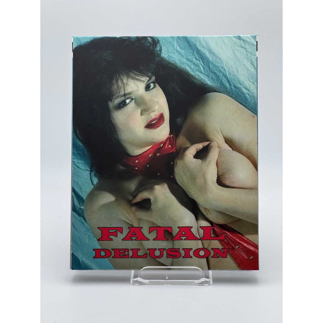 Saturn's Core Fatal Delusion Blu-Ray cover featuring a bloodied woman in blue underwear and a torn white shirt against a gray background