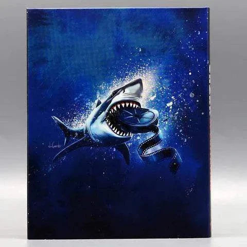 Sharksploitation Blu-Ray slipcover featuring a shark biting a film reel on dark blue background