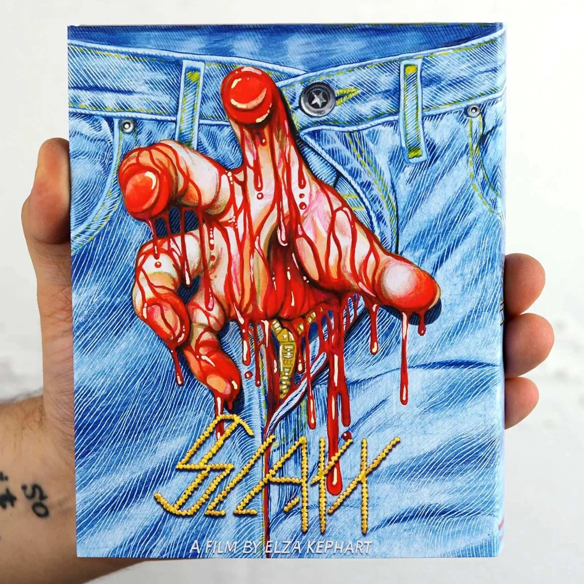 Shudder Slaxx Blu-ray cover featuring bloody hand emerging from blue jeans with slipcover