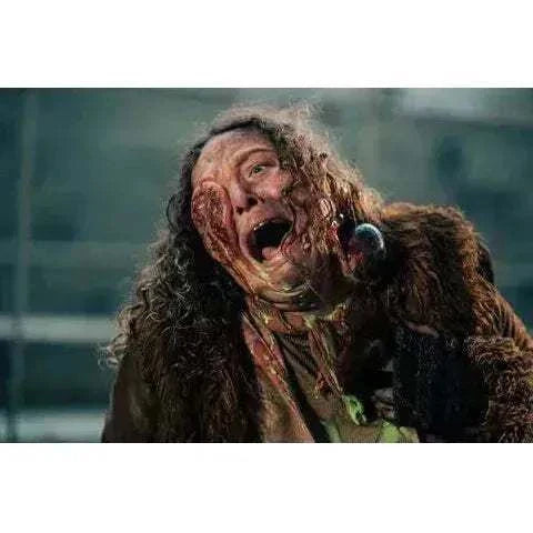 Scene from Street Trash 2024 horror film showing a distressed character with severe facial melting effects, Vinegar Syndrome Pictures Blu-ray release.